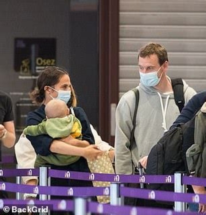 Alicia Vikander cradles a baby while at an airport with husband Michael Fassbender in Paris