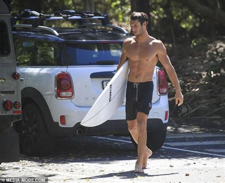 Love Island star Elias Chigros shows off his muscular frame as he goes surfing in Byron Bay