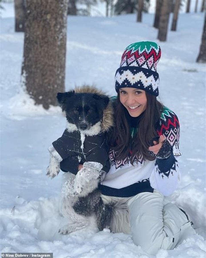 Nina Dobrev swaps her cosy skiing gear for a red bikini as she takes a brave dive into the snow