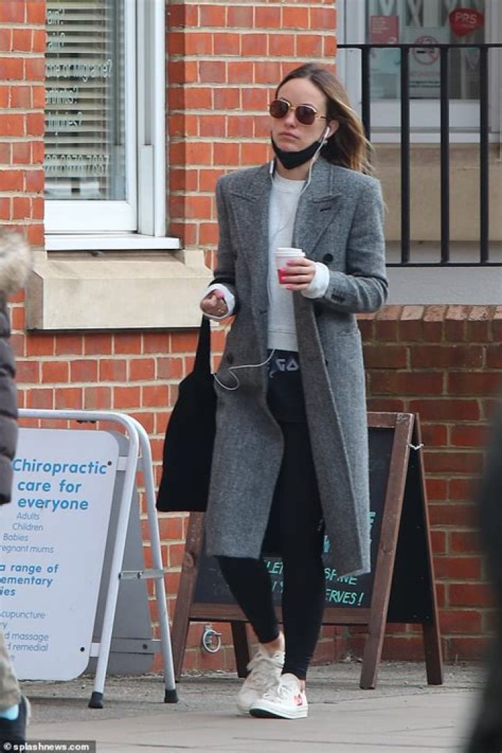 Olivia Wilde wears tailored grey coat and gold sunglasses for London coffee run