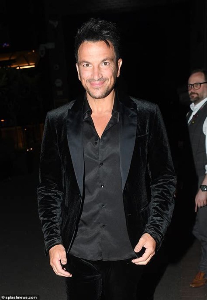 Peter Andre flashes a smile as he leaves the theatre amid his upset over manhood saga