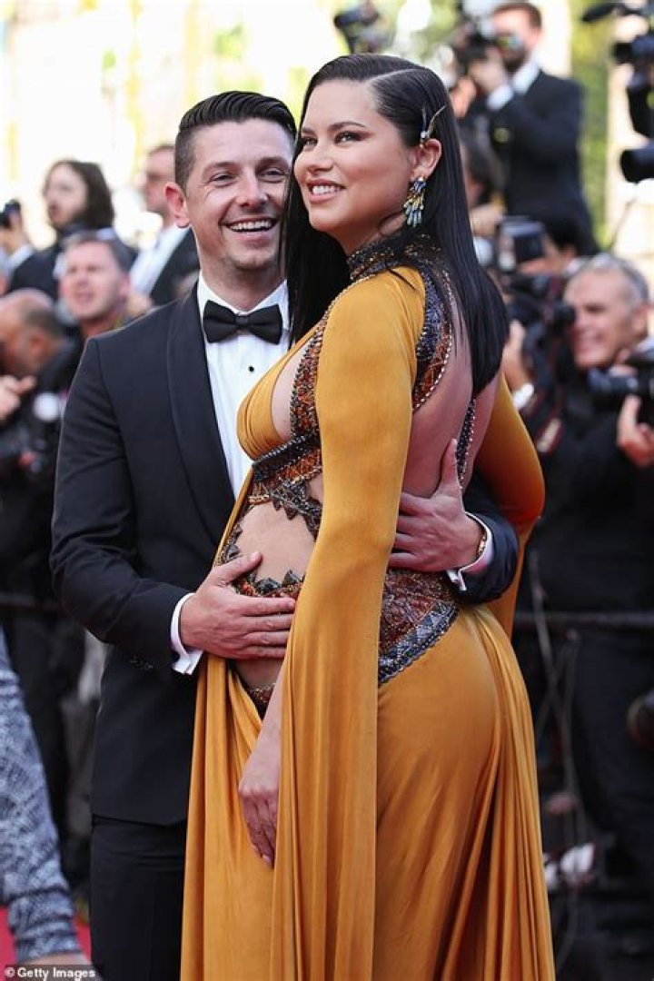 Pregnant Adriana Lima displays her bump as she shares a kiss with her beau Andre Lemmers in Cannes