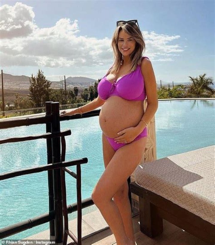 Pregnant Rhian Sugden cradles her growing bump on a beach day in Majorca after revealing she's expecting her first child after spending £150k on eight rounds of IVF
