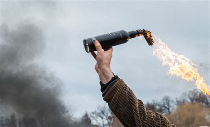 Shocking moment a Molotov cocktail explodes inside a store as terrified staff rush through flames to escape