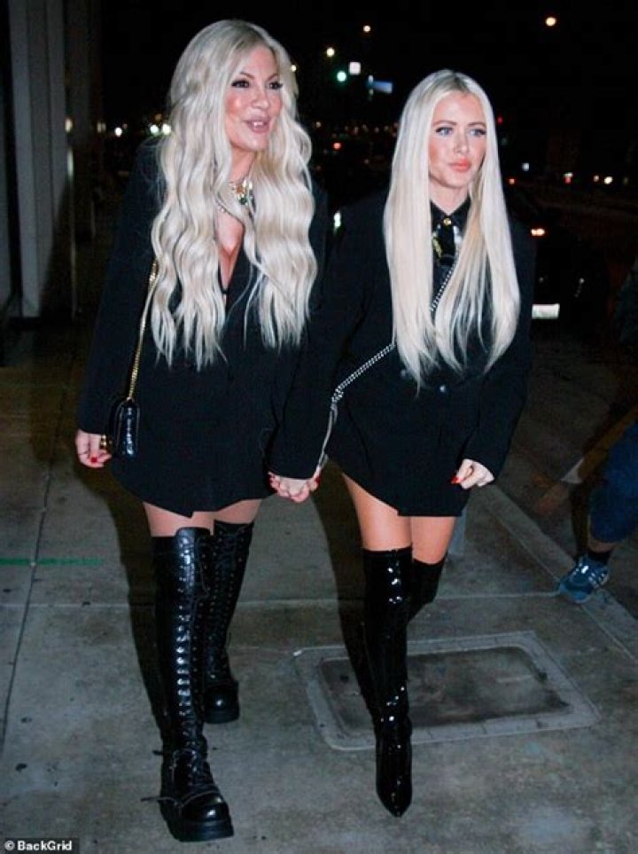 Tori Spelling flashes cleavage as she heads to Catch in plunging LBD and thigh-high boots