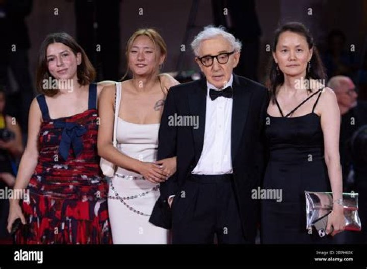 Woody Allen, 87, is booed by critics as  he arrives with wife Soon-Yi Previn, 52, - who is his ex-girlfriend's adopted daughter - and their children at the controversial director's Coup De Chance screening in Venice
